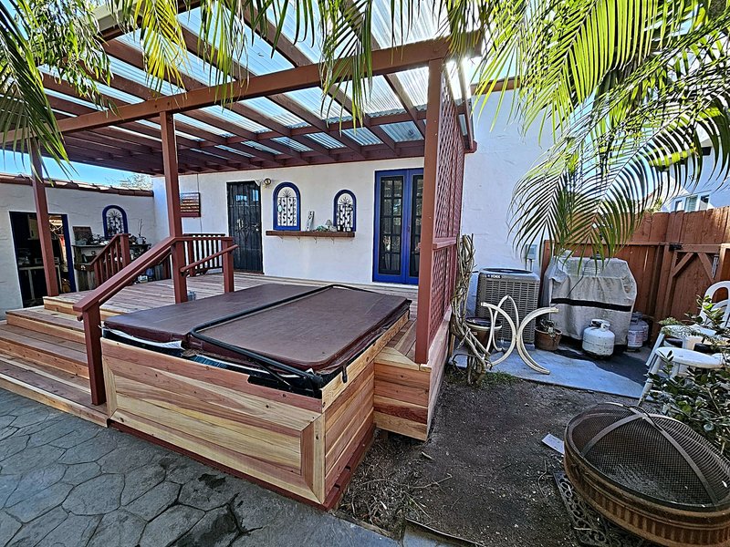 Close view of the hot tub built into the deck and framed in cedar, under the covered pergola