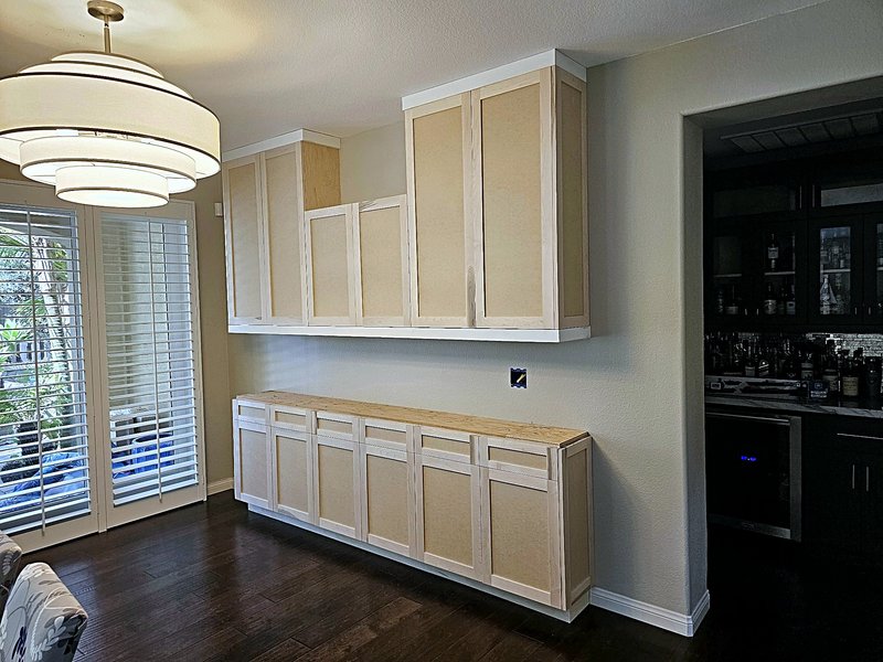 Dining room built-in buffet and wall cabinets installed in unfinished wood, before paint and countertop